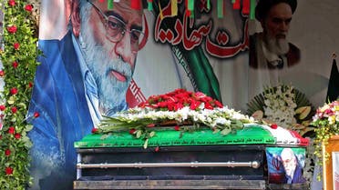 A handout picture provided by Iran’s Defense Ministry on November 30, 2020 shows the coffin of slain top nuclear scientist Mohsen Fakhrizadeh in front of a large display depicting Fakhrizadeh next to Iran’s supreme leader Ayatollah Ali Khamenei during the funeral ceremony in Tehran. (AFP)