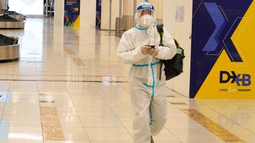 A passenger in a full, disposable hazmat suit arrives at the baggage claim area of Dubai International Airport's Terminal 3 in Dubai on Nov. 26, 2020. (AP)