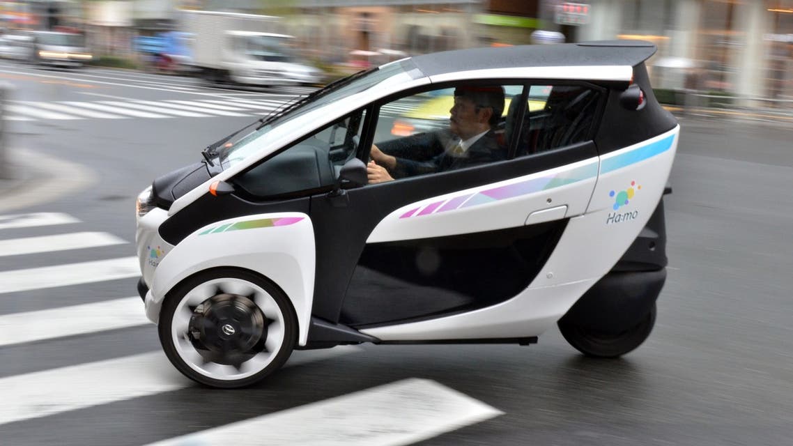 an employee of parking operator 'Park 24' drives Toyota's electric personal mobility vehicle i-Road in Tokyo. (AFP)