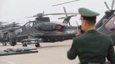 A military personnel speaks on his walkie-talkie before a military helicopter from Chinese People's Liberation Army (PLA) Air Force during the China Helicopter Exposition in Tianjin, China October 10, 2019. Picture taken October 10, 2019. REUTERS/Stringer ATTENTION EDITORS - THIS IMAGE WAS PROVIDED BY A THIRD PARTY. CHINA OUT.