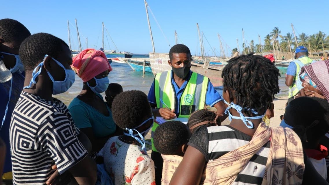 This handout picture taken on November 6, 2020 in Pemba, northern Mozambique, by IOM (International Organization for Migration) shows internally displaced people being assisted by the IOM Displacement Tracking Matrix (DTM) team conducting Emergency Tracking upon their arrival at Pemba’s Paquitequete beach by boat. They are counting the number of boats and displaced people who arrived at Paquitequete beach. They record the number of women, men and children and their vulnerabilities (number who are elderly, pregnant, ill). The activity is carried out in close cooperation with Government of Mozambique authorities. The data is used for humanitarian response planning. (Sandra Black/IOM/AFP)