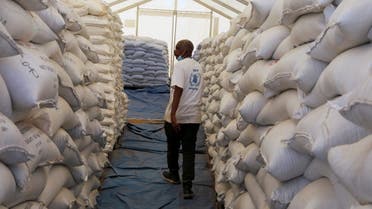 World Food Programme employee walks between sacks of food at the Um Rakuba refugee camp which houses Ethiopian refugees fleeing the fighting in the Tigray region, on the Sudan-Ethiopia border in Sudan, November 29, 2020. REUTERS/Baz Ratner