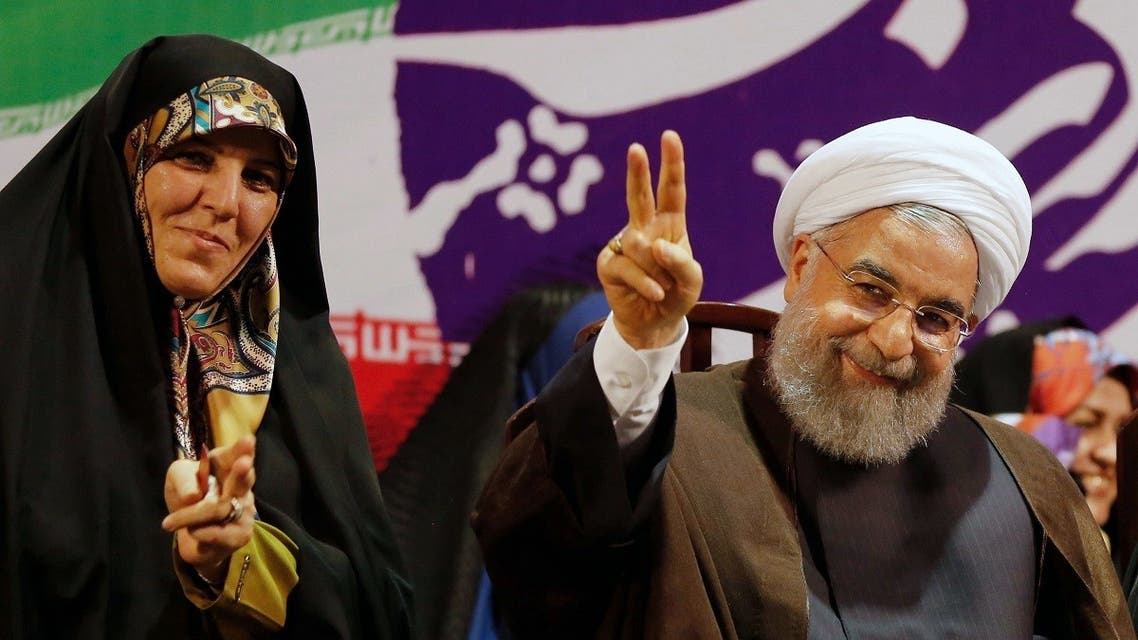 Iranian President and presidential candidate Hassan Rouhani gestures during a campaign rally in Tehran on May 9, 2017, with vice president for women's affairs Shahindokht Molaverdi (L) seated next to him. (STR/AFP)