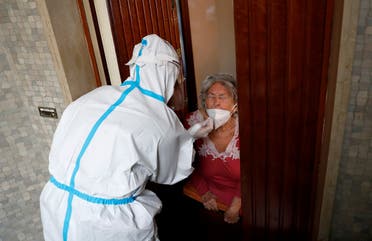 A medical worker visit the home of a patient suspected to be suffering from the coronavirus disease to carry out a swab test, Rome, Italy, December 3, 2020. (Reuters/Remo Casilli)