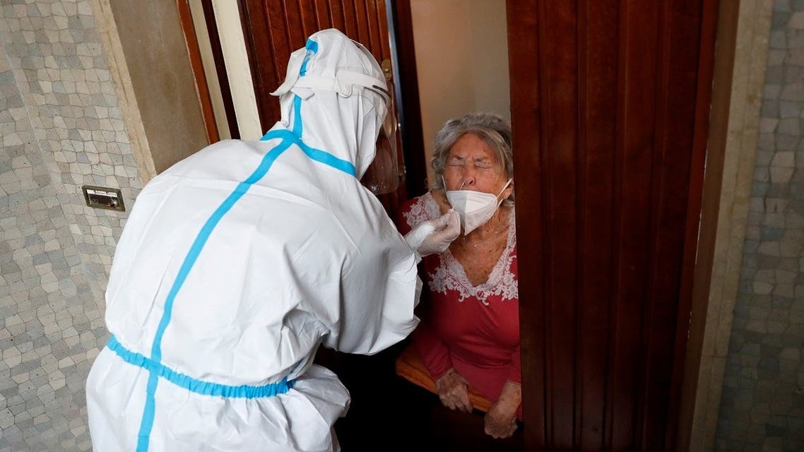 A medical worker visit the home of a patient suspected to be suffering from the coronavirus disease to carry out a swab test, Rome, Italy, December 3, 2020. (Reuters/Remo Casilli)