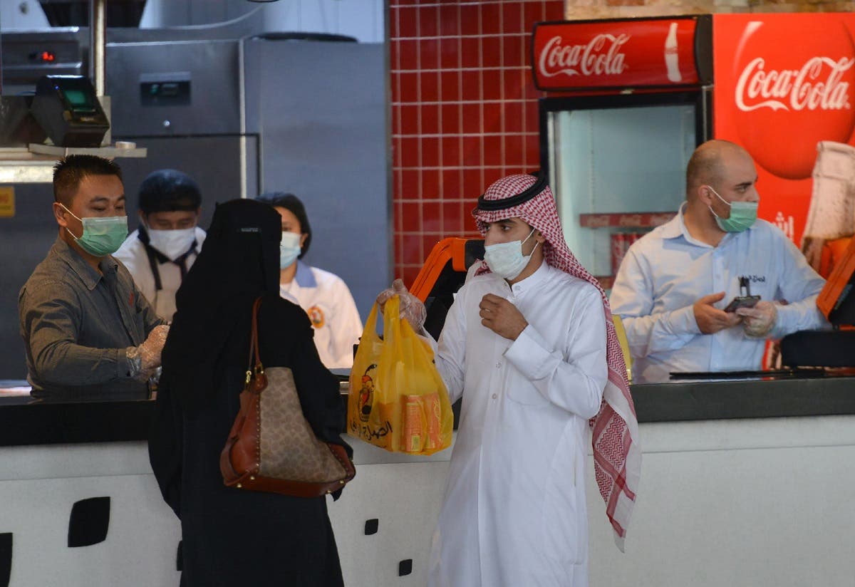 A couple collects an order from a restaurant in a shopping mall in the Saudi capital Riyadh. (File photo: AFP)