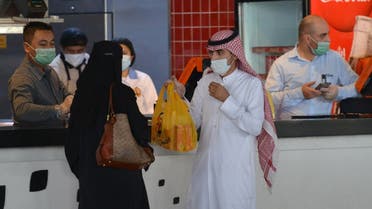 A couple collects an order from a restaurant in a shopping mall in the Saudi capital Riyadh on June 4, 2020, after it reopened following the easing of restrictions to stem the spread of the coronavirus. (Fayez Nureldine/AFP)