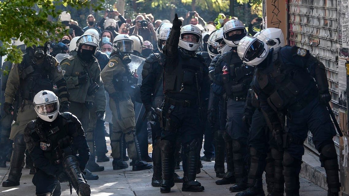 Police chases a group of youth who unfurled a banner in Athens' Exarchia district on December 6, 2020 during an attempted rally to mark the 2008 police killing of 15-year-old Alexandros Grigoropoulos. (Louisa Gouliamaki/AFP)