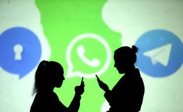 Silhouettes of mobile users are seen next to logos of social media apps Signal, Whatsapp and Telegram projected on a screen in this picture illustration. (Reuters)