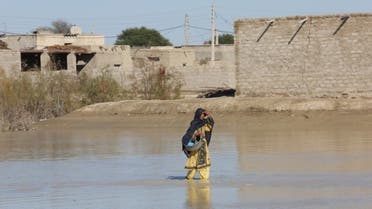 An Iranian woman walks through a flooded road on January 13, 2020 in the village of Dashtiari in Iran's Sistan-Baluchistan region, as severe downpour led to floods across region, blocking roads and damaging homes. (Alireza Masoumi/ISNA/AFP)