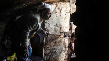 A man at the entrance of a cave where a Yemeni family has sought refuge due to poverty and lack of housing, west of the suburbs of Yemen's third-city of Taez on December 2, 2020. (AFP)