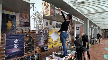University students put up pro-democracy posters at a Lennon wall in the University of Hong Kong, Tuesday, Sept. 29, 2020. (AP)