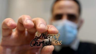 Palestinian Christian jewelr Melad Al-Amash displays a piece of gold Jewelry reading ‘Merry Christmas’ at his store in Gaza City. (Reuters)