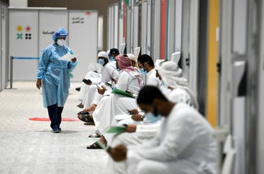 People sit as they wait their turn for vaccine trials in Abu Dhabi, UAE, October 6, 2020. (Reuters)