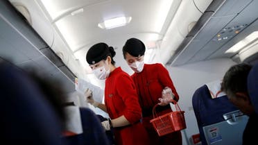 Flight attendants wear protective face masks amid the coronavirus outbreak. (Reuters)