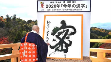 The Chinese kanji for 'mitsu', which was voted the 2020 kanji of the year, being written by Kiyomizu temple master Seihan Mori in Kyoto, Japan. (AFP)
