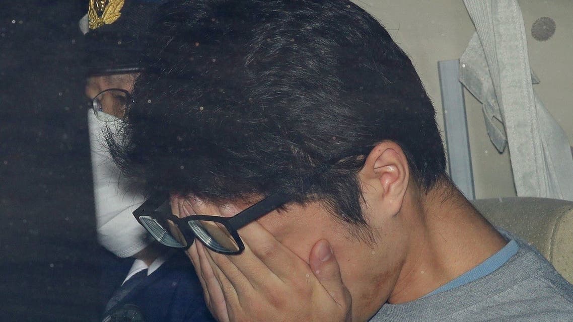 Takahiro Shiraishi covers his face inside a police car in Tokyo, in this photo taken by Kyodo November 2017 and released by Kyodo on December 15, 2020. (Reuters)