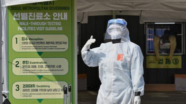 A Seoul city official wearing protective clothing waits to guide visitors for the COVID-19 coronavirus test at a walk-thru testing station set up at Jamsil Sports Complex in Seoul on April 3, 2020. (AFP)