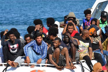 Migrants from Tunisia and Lybia arrive onboard of an Italian Guardia Costiera (Coast Guard) boat in the Italian Pelagie Island of Lampedusa on August 1, 2020. (AFP)