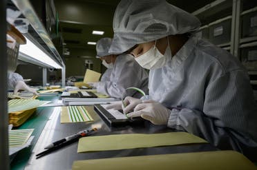 Staff members prepare diagnostic components to be used in COVID-19 novel coronavirus testing kits on a production line at the SD Biosensor bio-diagnostic company near Cheongju, south of Seoul on March 27, 2020. (AFP)