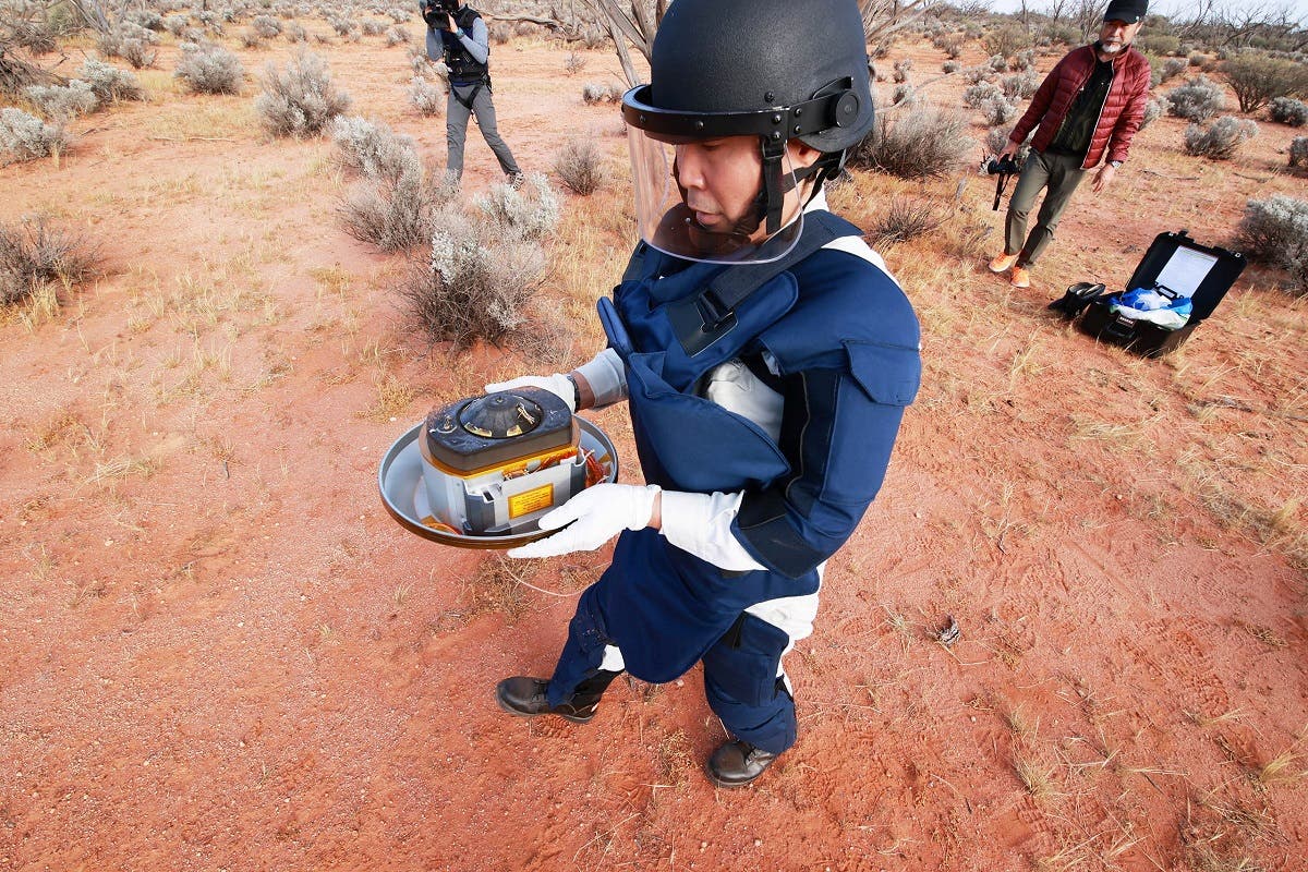 A member of Japan Aerospace Exploration Agency (JAXA) collects Hayabusa2’s capsule carrying the first extensive samples of an asteroid after it landed in the Woomera restricted area, Australia, on December 6, 2020. (Reuters)