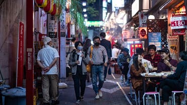 People wearing face masks as a preventive measure against the Covid-19 coronavirus visit the restaurant area of Omoide Yokocho alleyway in Shinjuku district of Tokyo. (AFP)