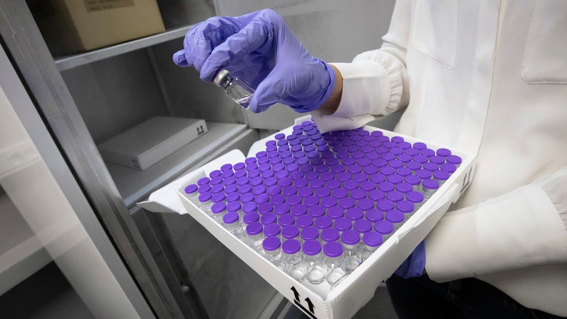 A worker holds up a vial of a dummy vaccine during training for how the coronavirus (COVID-19) vaccination will be transported and stored at the Centre Hospitalier Universitaire Ambroise Pare in Mons, Belgium, Thursday, December 17, 2020. (Benoit Doppagne, Pool via The Associated Press)
