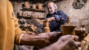 Syrian-Armenian potter Misak Antranik Petros uses an ancient pottery wheel to churn different types of pots at his workshop located inside an ancient mud-brick house near the city of Qamishli. (AFP)