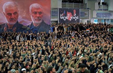 A handout picture provided by the office of Iran's Supreme Leader Ayatollah Ali Khamenei on January 17, 2020 shows Iranians chanting slogans during friday prayers in the capital Tehran, under portraits of slain Iranian commander Qasem Soleimani (L) and Iraq's Hashed al-Shaabi military network deputy chief Abu Mahdi al-Muhandis. (AFP)