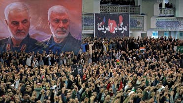 A handout picture provided by the office of Iran's Supreme Leader Ayatollah Ali Khamenei on January 17, 2020 shows Iranians chanting slogans during friday prayers in the capital Tehran, under portraits of slain Iranian commander Qasem Soleimani (L) and Iraq's Hashed al-Shaabi military network deputy chief Abu Mahdi al-Muhandis. (AFP)