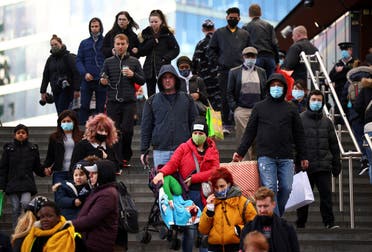 People carrying bags walk down the stairs outside the Westfield Stratford City shopping center, amid the coronavirus outbreak in London, Britain. (Reuters)