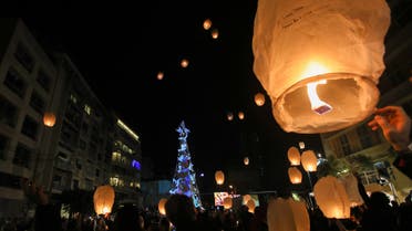 Lebanese launch lanterns in Beirut's Gemmayzeh neighborhood on December 20, 2020, during the lighting of a Christmas tree in memory of the victims of the August port blast. (AFP)