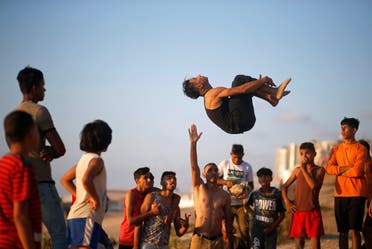 A Palestinian youth demonstrates his parkour skills on a beach as the coronavirus disease (COVID-19) restrictions ease in Gaza City. (Reuters)