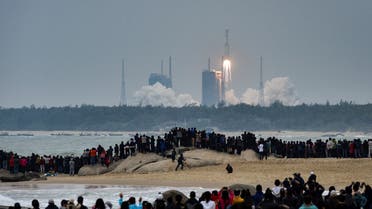 People watch a Long March-8 rocket, the latest China's Long March launch vehicle fleet, lifting off from the Wenchang Space Launch Center in southern China's Hainan province on December 22, 2020. (AFP)