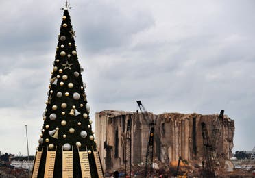 A Christmas tree decorated with names of those who died in the August explosion at the Beirut seaport is on display in front of damaged silos, in Beirut, Lebanon, Wednesday, December 23, 2020. (The Associated Press/Hussein Malla)