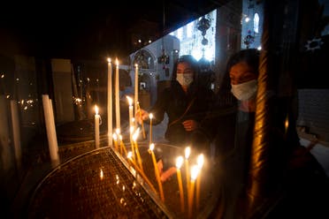 Christian worshippers light candles in the Church of the Nativity, traditionally believed to be the birthplace of Jesus Christ, in the West Bank city of Bethlehem, Monday, November 23, 2020. (The Associated Press/Majdi Mohammed)