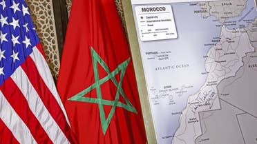 This file photo taken on December 12, 2020 shows (L to R) US and Moroccan flags next to a US State Department-authorised map of Morocco recognising the internationally-disputed territory of the Western Sahara (bearing a signature by US Ambassador to Morocco David T. Fischer) as a part of the North African kingdom, in Morocco's capital Rabat. (AFP)