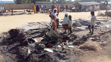 People stand amid the damage at a camp for displaced people after an attack by suspected Boko Haram insurgents in Dalori, Nigeria. (File photo: Reuters)