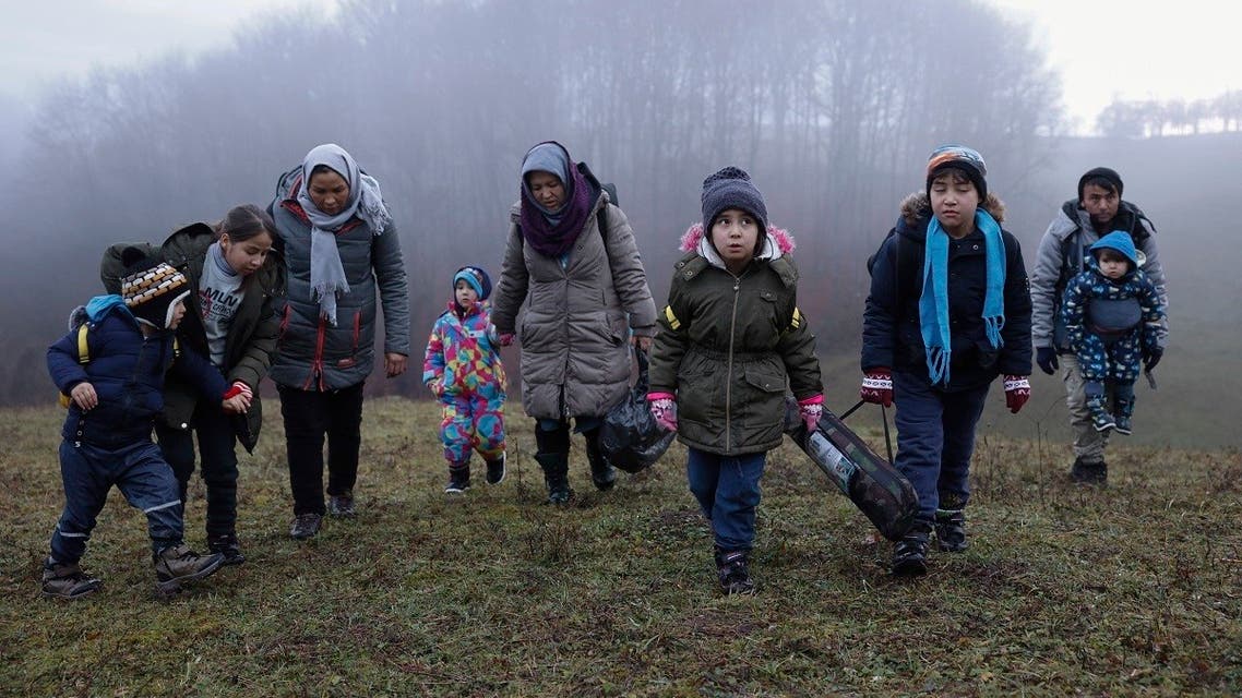 Two Afghan families walk in a clearing after leaving a Croatian forest near the Bosnian town of Velika Kladusa, Dec. 10, 2020. (AP/Marc Sanye)