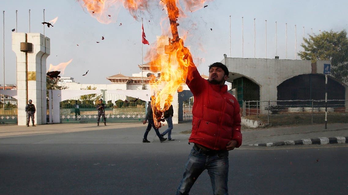A Nepalese protester burns an effigy of prime minister Khadga Prasad Oli in front of the parliament building in Kathmandu, Nepal, Sunday, Dec. 20, 2020. (AP/Niranjan Shrestha)