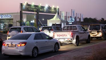 Kuwaitis line up for a PCR test at a COVID-19 drive-thru testing centre near Kuwait International Airport. (AFP)