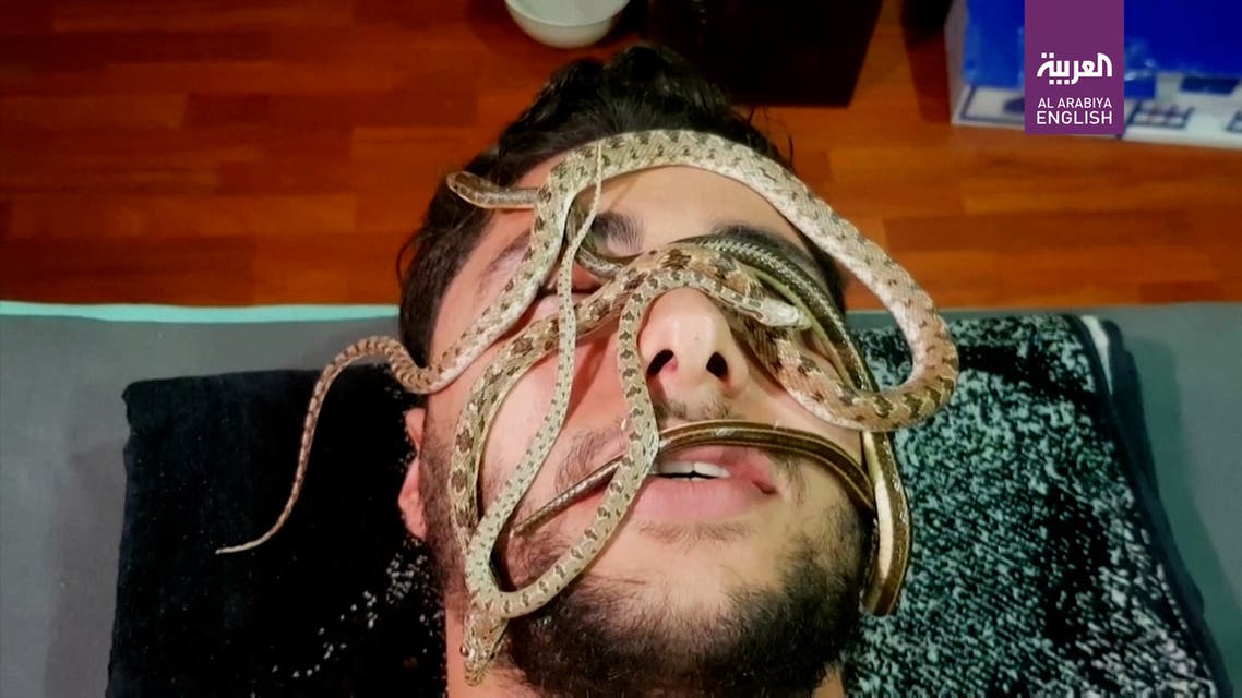 A customer in a small Cairo spa room that uses live snakes to offer pain relief. (Reuters)