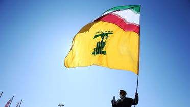 إيراني يحمل علم إيران وحزب الله في طهران (أرشيفية- رويترز)