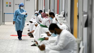 People sit as they wait their turn for vaccine trials at Abu Dhabi National Exhibition Centre in Abu Dhabi, United Arab Emirates, October 6, 2020. Picture taken October 6, 2020. (Reuters)