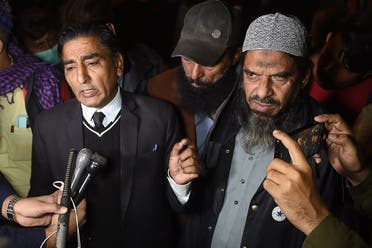 Sheikh Aslam (R), a relative of one of the accused of murdering US journalist Daniel Pearl and his lawyer Nadeem Azhar speak with media representatives outside a prison in Karachi on December 24, 2020. (AFP)