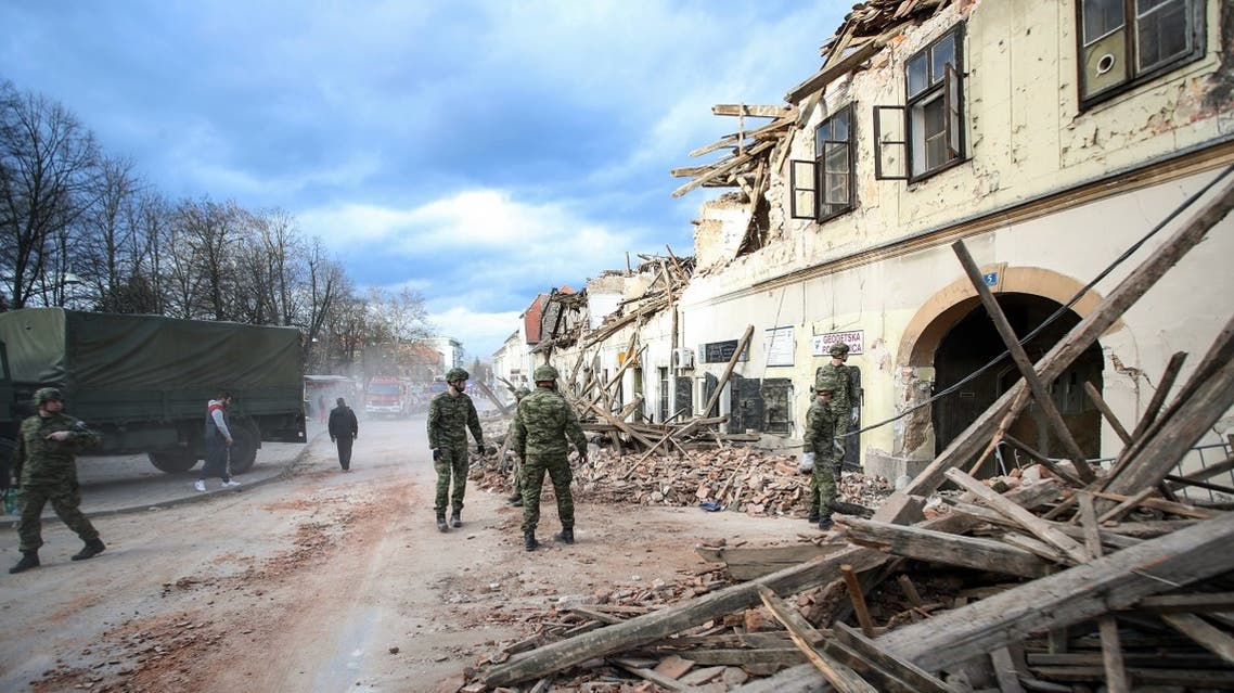 Croatian soldiers stand next wreckage and damaged buildings in Petrinja, some 50kms from Zagreb, after the town was hit by an earthquake of the magnitude of 6,4 on December 29, 2020. (AFP)