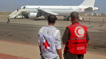 International Committee of the Red Cross (ICRC) and a Red Crescent volunteer look at an Airbus A320 aircraft at an airport in Yemen's southern city of Aden, the interim seat of the Yemeni government, on October 16, 2020. (AFP)
