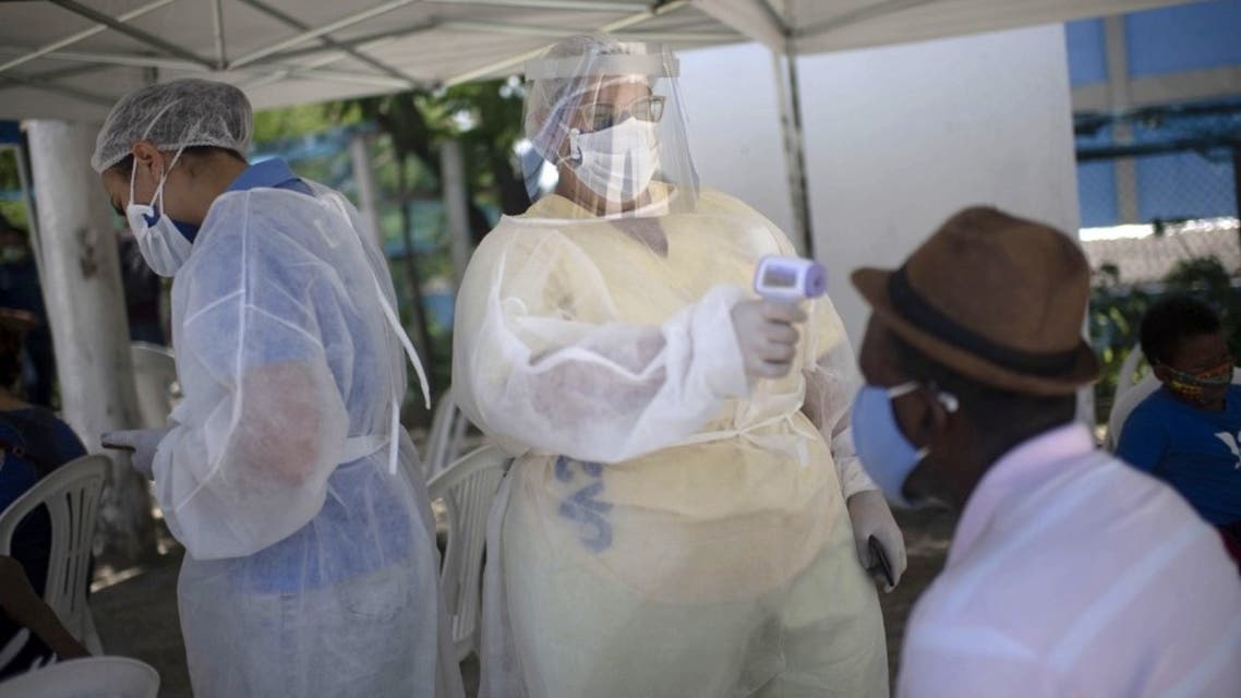 A health worker measures the body temperature of a man before undergoing a PCR test to screen for COVID-19 at a public health unit in Rio de Janeiro state, Brazil, on December 04, 2020. (AFP)
