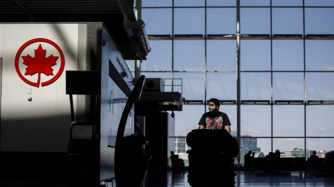 A passenger wheels his luggage near an Air Canada logo at Toronto Pearson International Airport on April 1, 2020 in Toronto, Canada. (AFP)