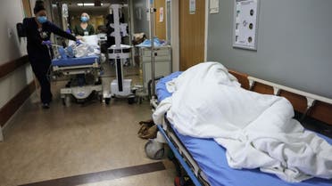A patient lies on a stretcher in the hallway of the overloaded Emergency Room at Providence St. Mary Medical Center amid a surge in COVID-19 patients in Southern California on December 23, 2020 in Apple Valley, California. (AFP)